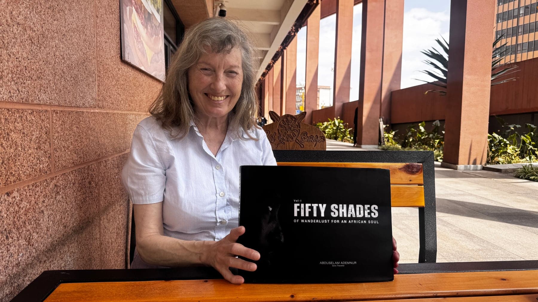 A reader holding Fifty Shades of Wanderlust for an African Soul