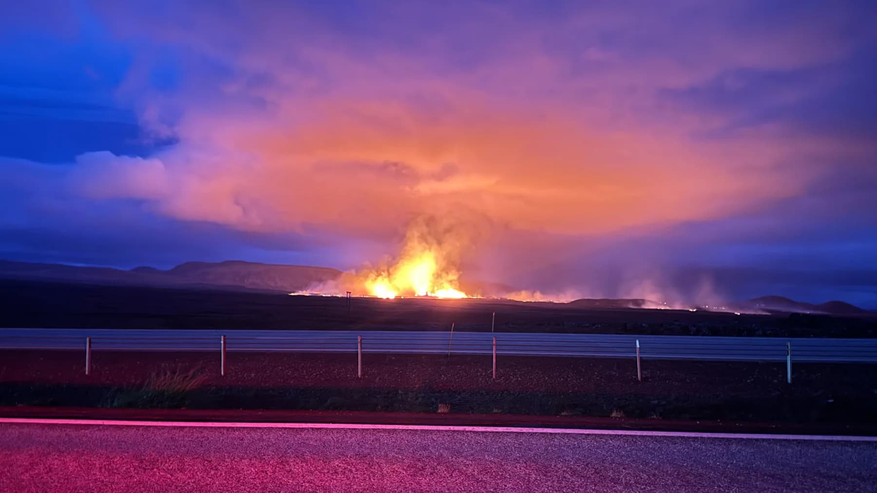 Volcanic eruption glowing beneath the evening sky in Iceland